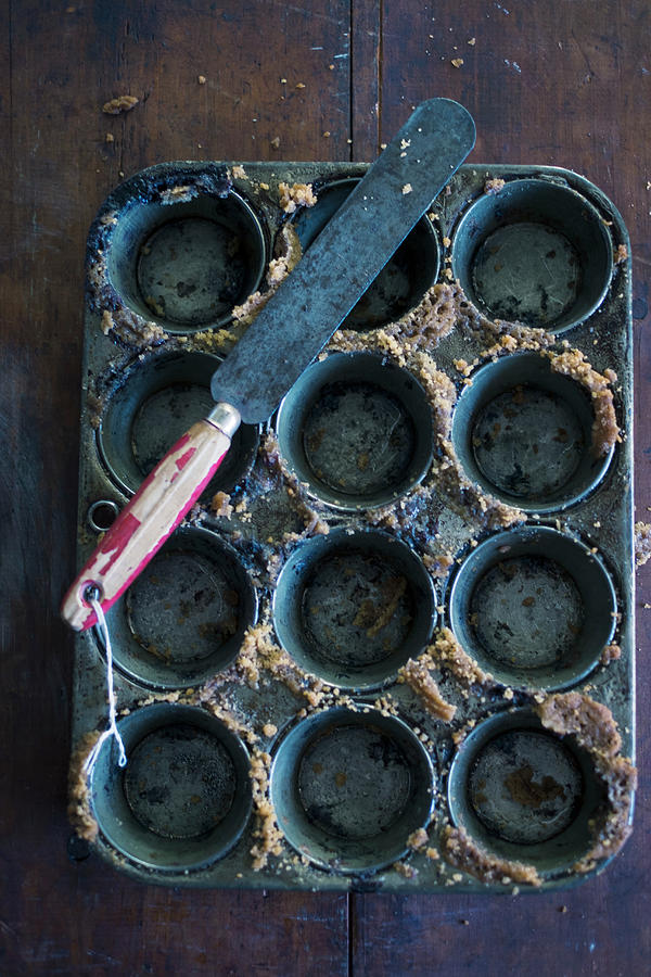 An Empty Muffin Tins With Cake Crumbs And A Palette Knife Photograph by Eising Studio