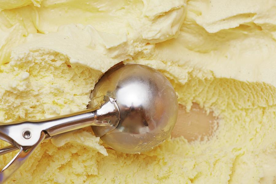 An Ice Cream Scoop Scooping Vanilla Ice Cream From A Container Photograph by Robert Kneschke
