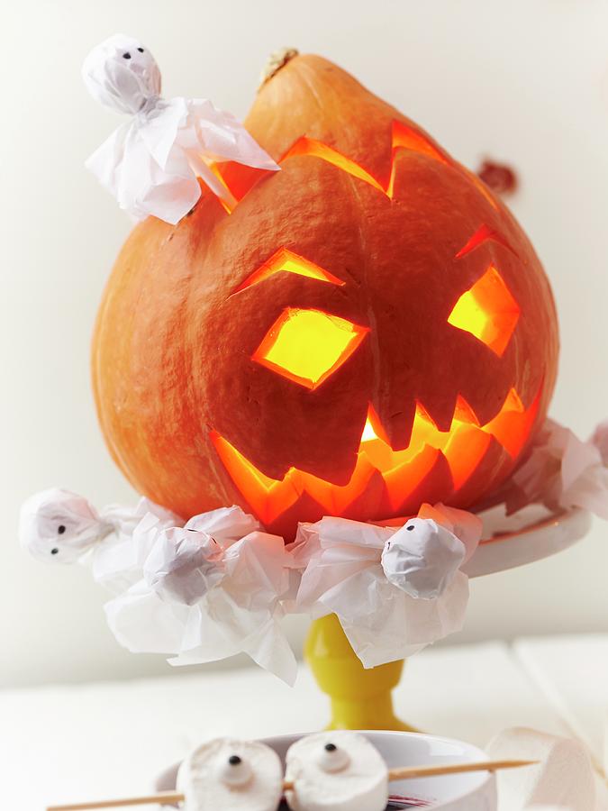 An Illuminated Halloween Pumpkin And Ghosts As Party Decorations Photograph by Hannah Kompanik