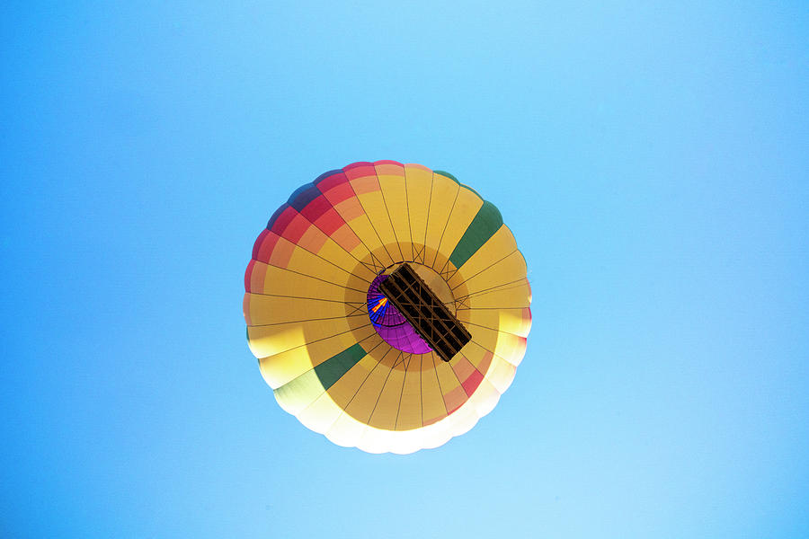 An Inflated Hot Air Balloon Ascends Into A Clear Blue Sky Photograph by ...