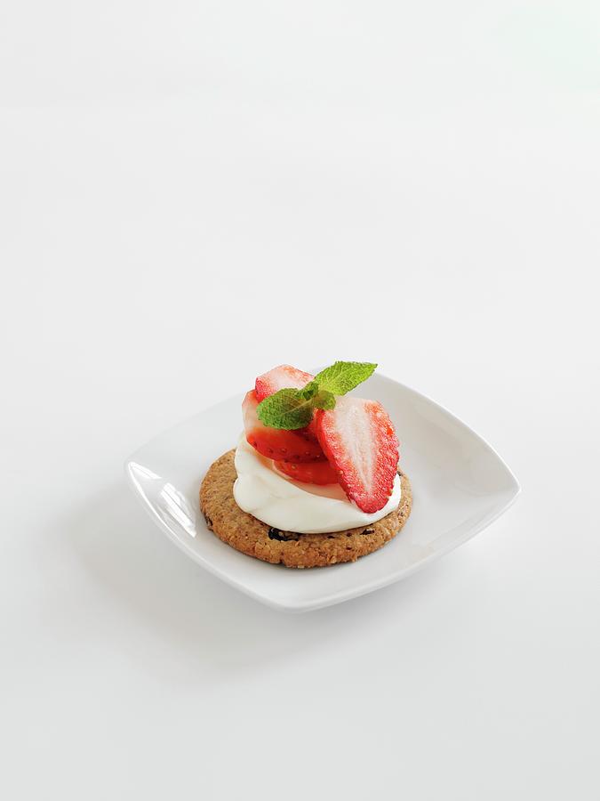 An Oat Cake Topped With Strawberries And Cream On A White Surface Photograph by Gareth Morgans