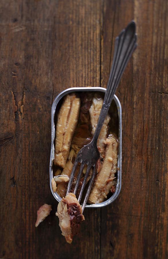 An Open Can Of Sardines With A Fork On A Wooden Table Photograph by Frank Weymann