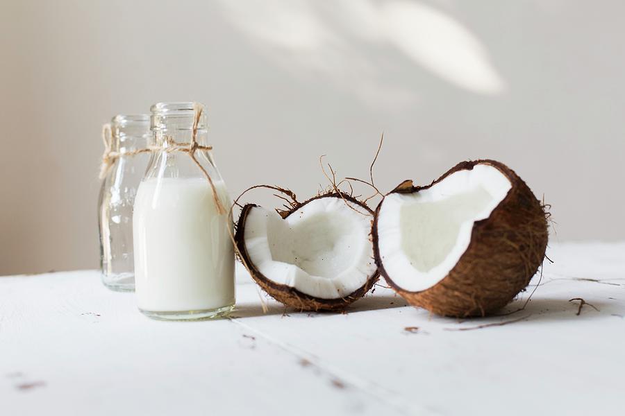 An Open Coconut And A Bottle Of Coconut Milk Photograph by Cath Lowe