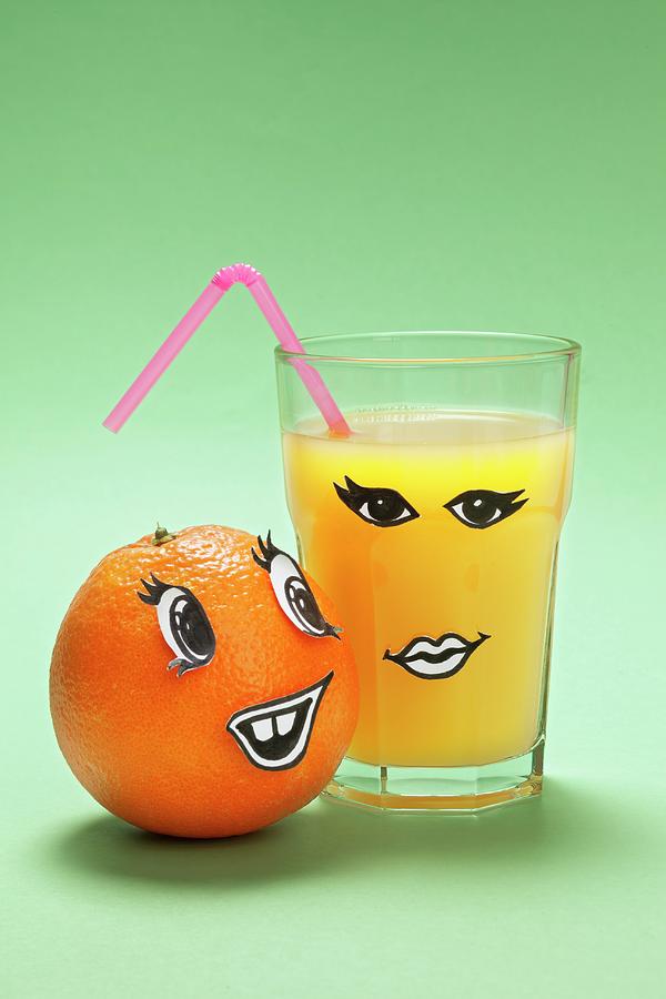 An Orange And A Glass Of Orange Juice With Faces Photograph by Krger & Gross