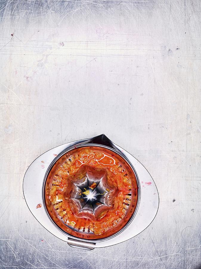 An Orange Juicer With Leftover Juiced Blood Orange On A Stainless Steel Surface Photograph by Peter Rees