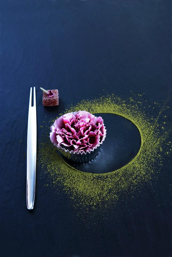 An Oriental Fork Next To A Carnation In A Muffin Case And Green Tea Powder On A Black Surface Photograph by Matteo Manduzio