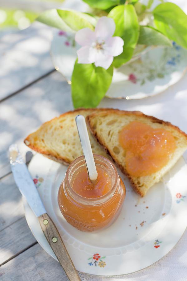 An Outdoor Breakfast With Quince Marmalade In A Jar And On White Bread, With Quince Flowers And Branches Photograph by Sabine Lscher