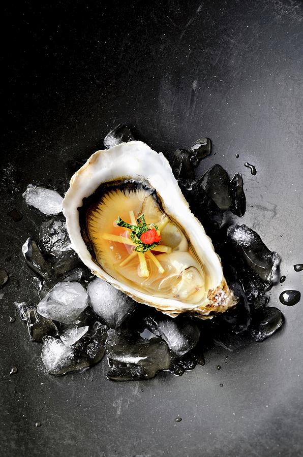 An Oyster With Ginger, Miso And Chilli On Ice Cubes Photograph by Jamie Watson
