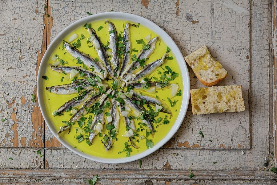 Anchovies In Garlic Oil Served With Herbs And Bread top View Photograph by Sabine Steffens