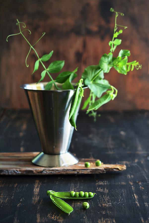 And Open People And A Sprig Of Peas In A Measuring Cup Photograph by Mariola Streim