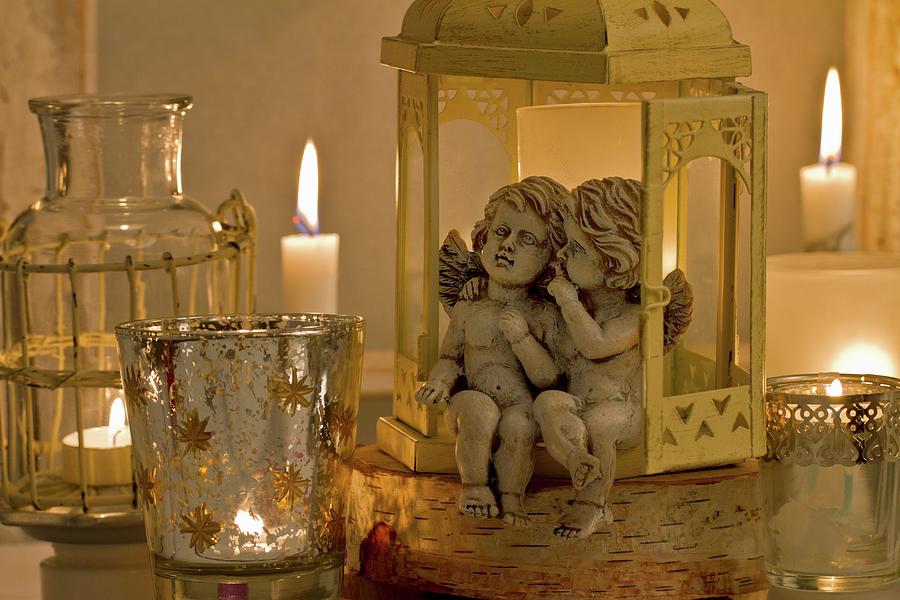Angel Figurines Sitting In Lantern And Tea Light Holders With Lit Candles Photograph by Uwe Merkel