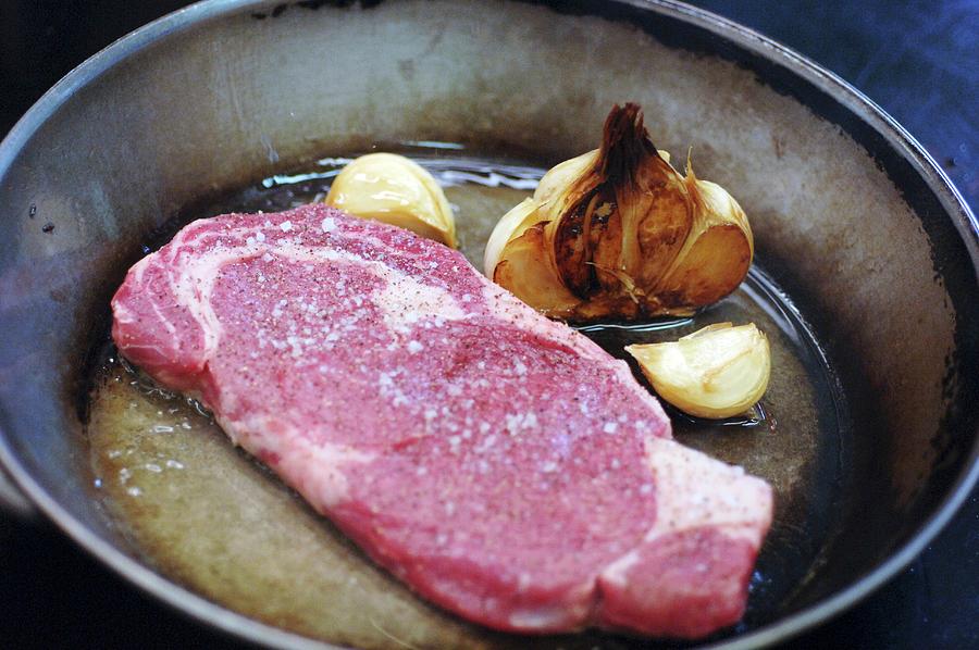 Angus Beef Steak With Garlic In A Frying Pan Photograph by Karl-heinz Hug