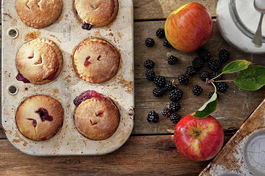 Apple And Blackberry Pies In A Baking Tin With Ingredients Next To It Photograph by George Blomfield
