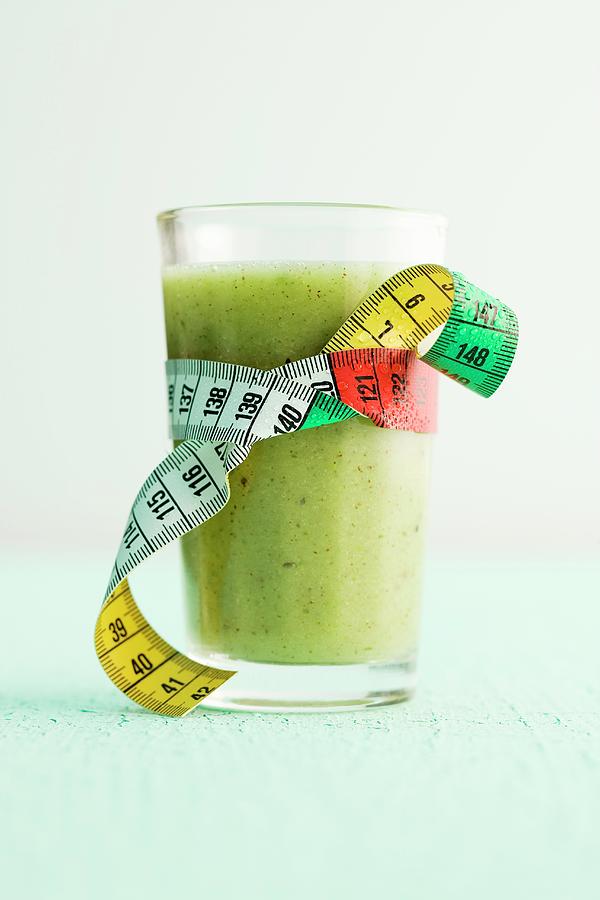 Apple And Kiwi Smoothie In A Glass With A Measuring Tape Photograph by Michael Wissing