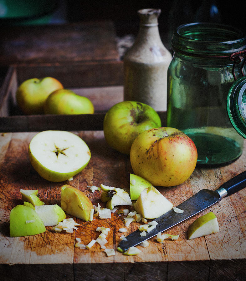 Apples And Chopped Apples On Rustic Wooden Board Photograph by Catherine Gratwicke