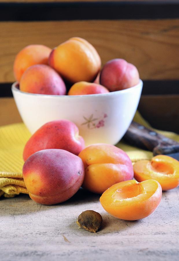 Apricots In A Bowl And On A Chopping Board Photograph by Mario Matassa