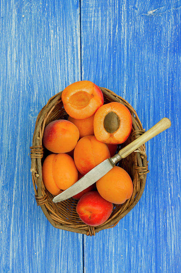 Apricots In Basket With Knife On Table Photograph by Westend61
