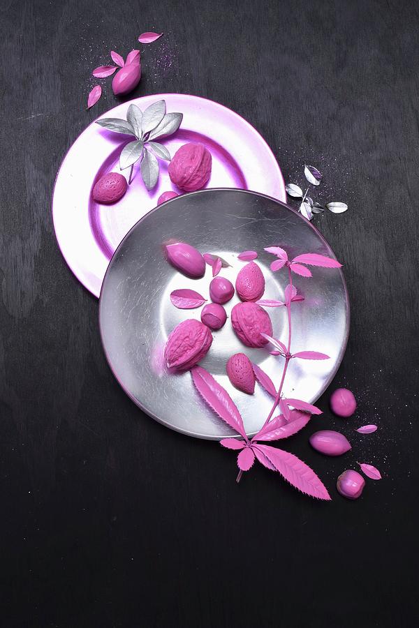 Arrangement Of Pink Nuts And Leaves On Plates Photograph by Elli Briest
