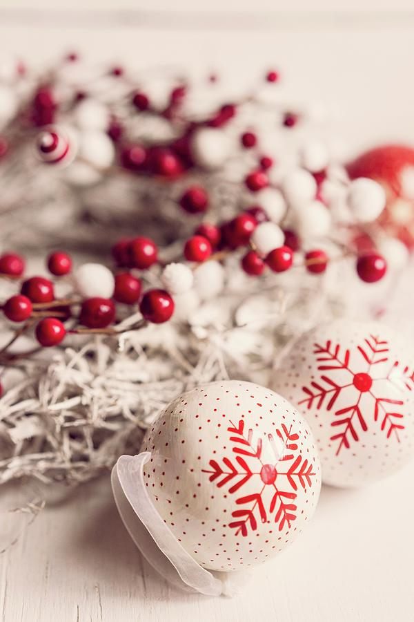 Arrangement Of Two Red And White Baubles Next To White Wreath With Red Artificial Berries Photograph by Alena Haurylik