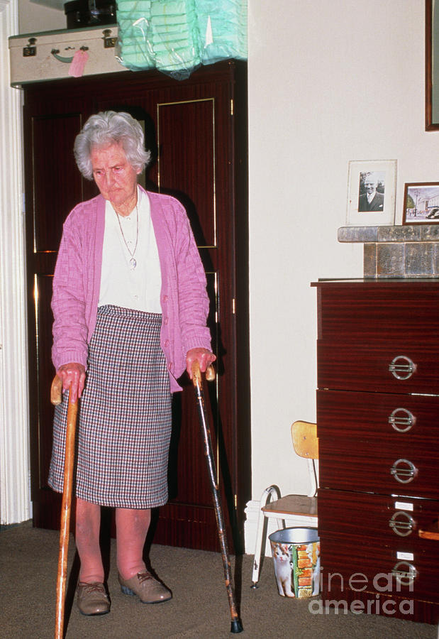 Arthritic Elderly Woman Walks With Walking Sticks Photograph by Conor ...