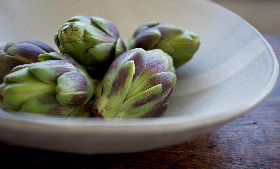 Artichokes In A Beige Bowl On A Wooden Table Photograph by Ryla Campbell