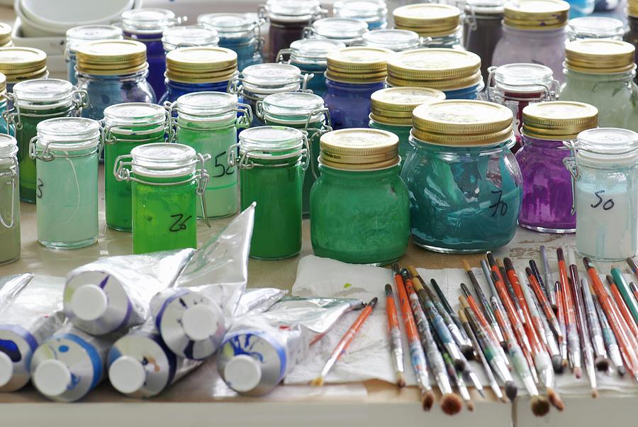 Artists Workbench: Tubes Of Paint, Paintbrushes And Glass Jars Holding Numerous Paints Photograph by Nele Braas