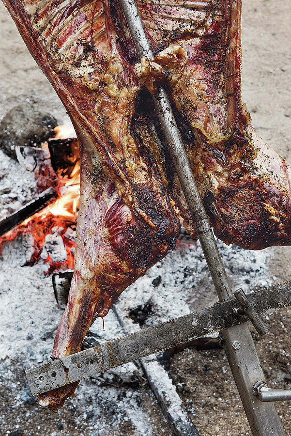 Asado  A Whole Lamb Being Grilled On A Spit Photograph by Tre Torri