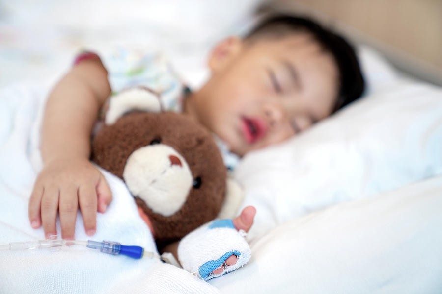 Asian baby sleep with teddy bear and saline on the bed in Hospit Photograph by Anek Suwannaphoom