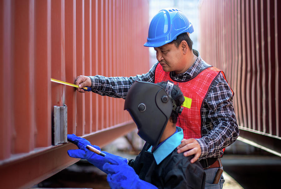 Factory Photograph - Asian engineer checking and measure a repair part  by Anek Suwannaphoom