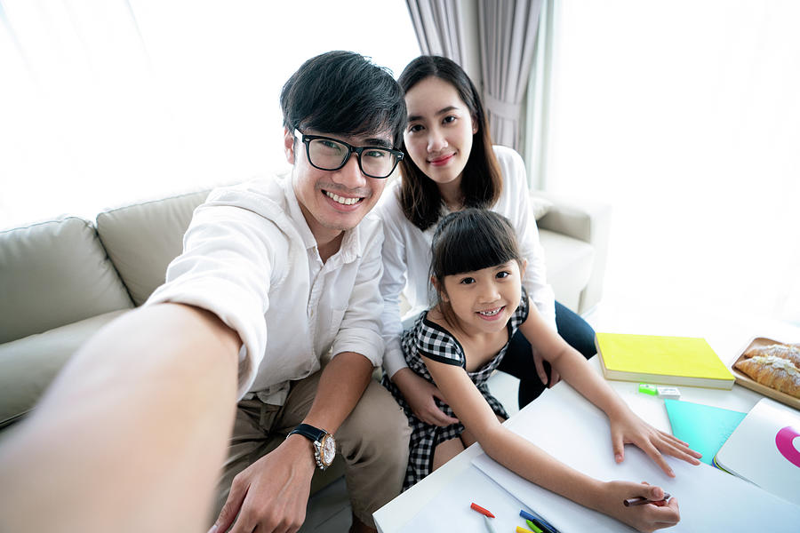 Asian family do homework and take selfie by smartphone  Photograph by Anek Suwannaphoom