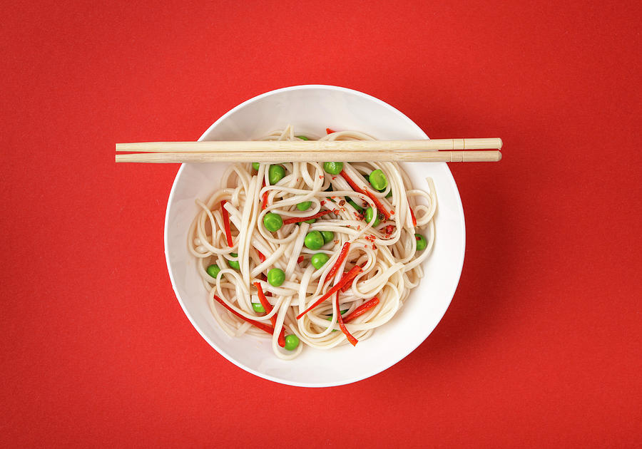 Asian Noodles With Vegetables, Green Peas And Red Pepper In White Bowl With Wooden Chopsticks Photograph by Olena Yeromenko
