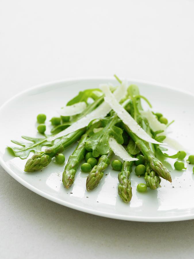 Asparagas And Peas With Parmesan Shavings On A White Plate Photograph by Will Shaddock Photography