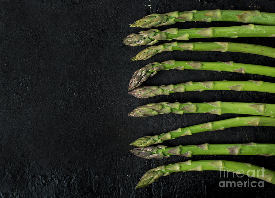Asparagus on rustic black background Photograph by Jelena Jovanovic