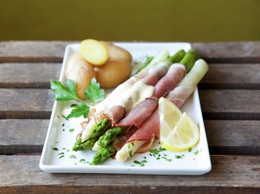 Asparagus Wrapped In Ham With Hollandaise Sauce And Potatoes Photograph by Foodografix