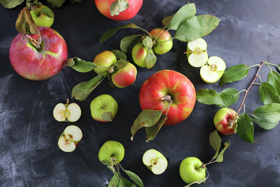 Assorted Apples With Leaves On A Slate Platter Photograph by Emily Clifton