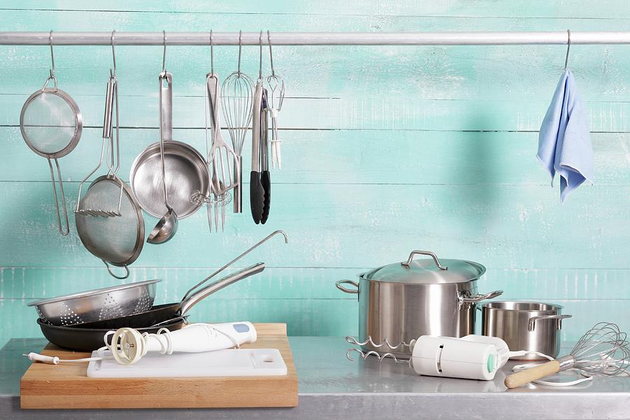 Assorted Kitchen Utensils On A Stainless Steel Unit And Hanging On A Metal Rod Photograph by Garten, Peter