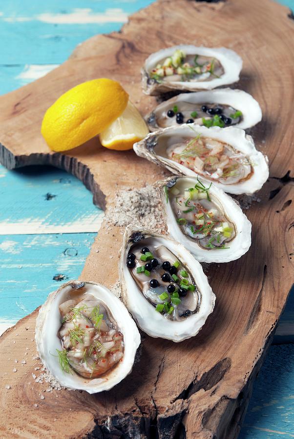 Assorted Oysters On A Plank Of Wood Photograph by Spyros Bourboulis
