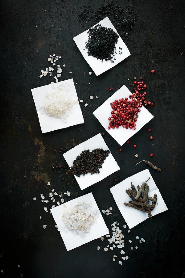 Assorted Types Of Salt And Pepper On Paper Photograph by Rafael Pranschke