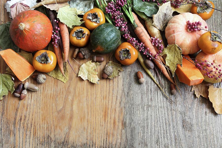 Assorted Varieties Of Autumn Vegetables And Japanese Persimmon On A Wooden Surface Photograph by Milly Kay