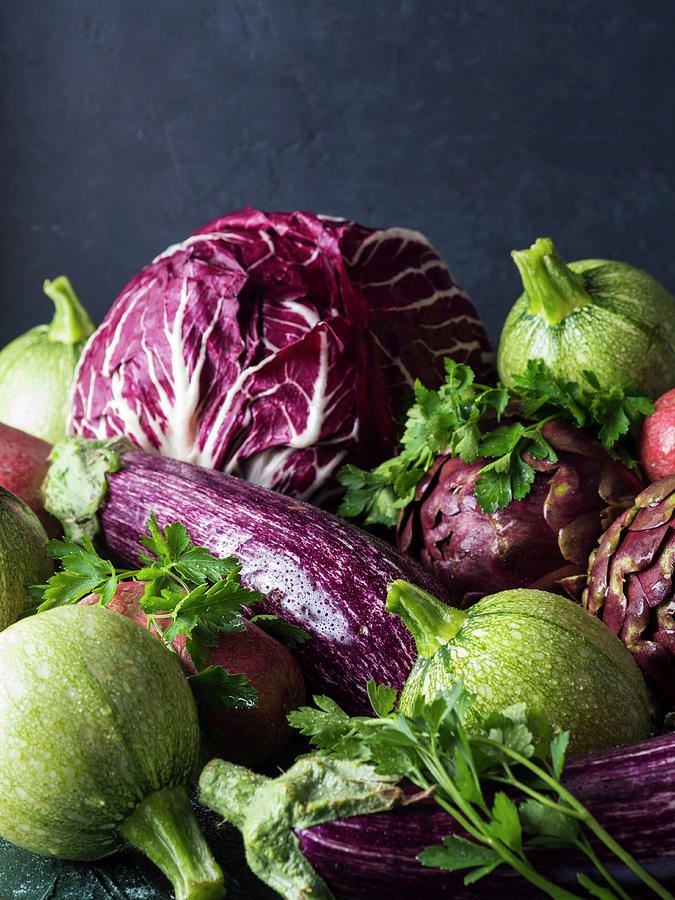 Assortment Of Raw Green And Purple Vegetables - Chicory, Red Potatoes, Zucchini, Artichokes And Aubergines - On Black Background Photograph by Sofya Bolotina