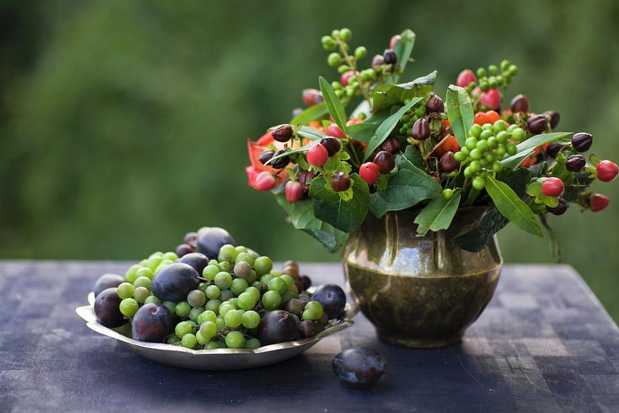 Autumn Posy Of St Johns Wort Berries In Brass Vase Next To Zinc Dish Of Grapes And Plums Photograph by Alicja Koll