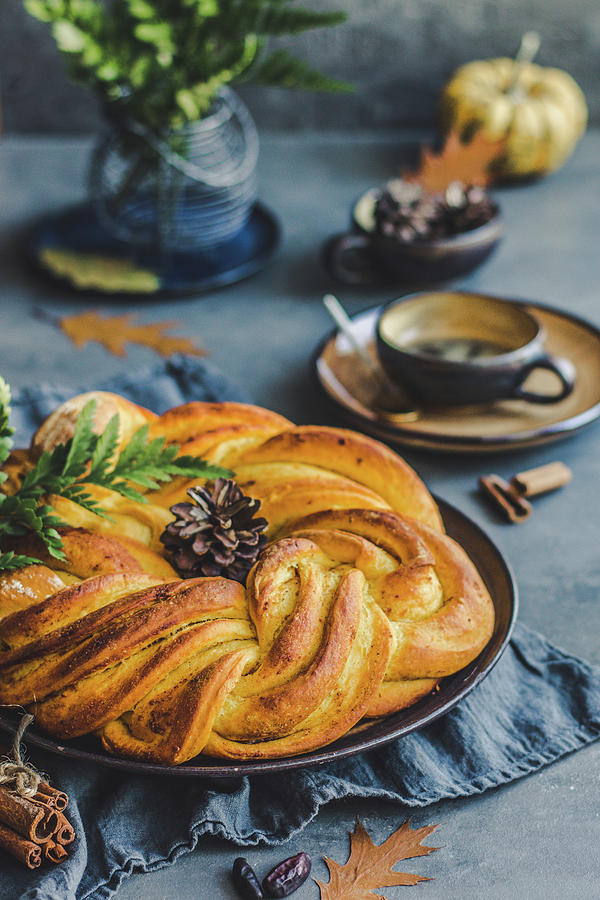 Autumn Yeast Cinnamon-pumpkin Cake In A Fancy Wreath Shape, Coffee In The Background Photograph by Diana Kowalczyk