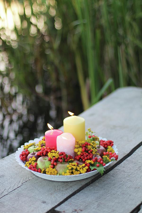 Autumnal Arrangement Of Candles, Berries, Apples And Flowers On Outdoor Table Photograph by Sylvia E.k Photography