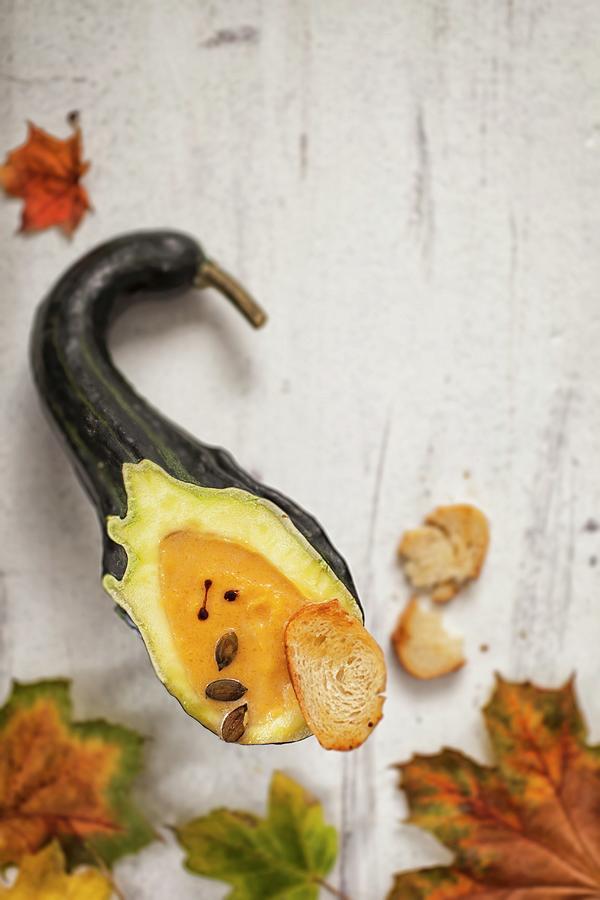 Autumnal Pumpkin Soup Served In A Hollowed-out Pumpkin Photograph by Jan Prerovsky