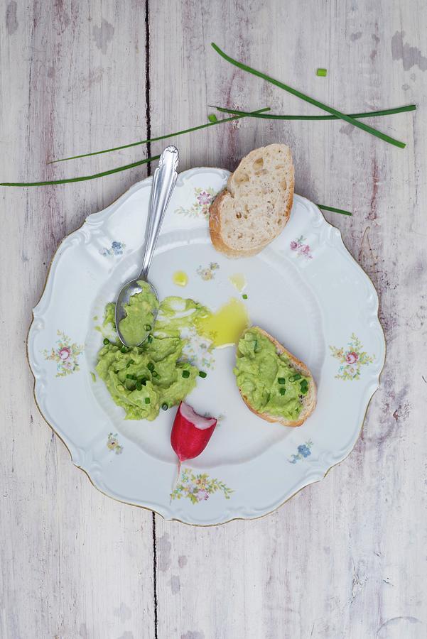 Avocado Cream With Chives And Olive Oil On A Porcelain Plate With A Slice Of Baguette And Radishes Photograph by Angelika Grossmann