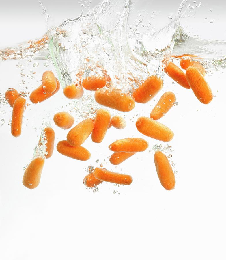 Baby Carrots Falling Into Water Photograph by King, Dave