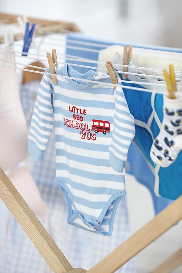 Baby Clothes Hanging On A Clothes Rack Photograph by Biglife