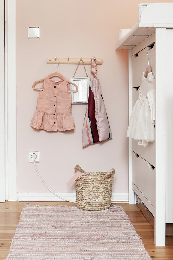 Baby Clothes On Coat Rack Next To Changing Unit Photograph by Hej.hem Interior