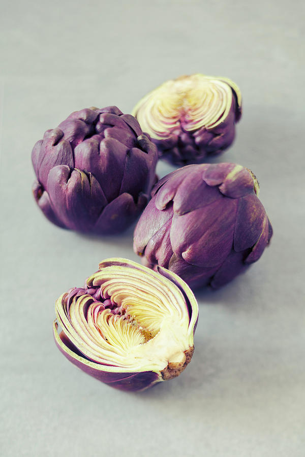 Baby Purple Artichokes, Whole And Halved Photograph by Jan Wischnewski