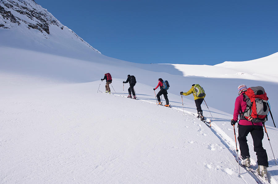 Backcountry Skiers Climbing Snowy Slope Photograph by Darryl Leniuk